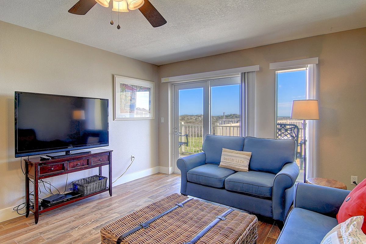 Unwind in your comfortable living room with plush seating, modern entertainment, and stunning views through floor-to-ceiling windows.
