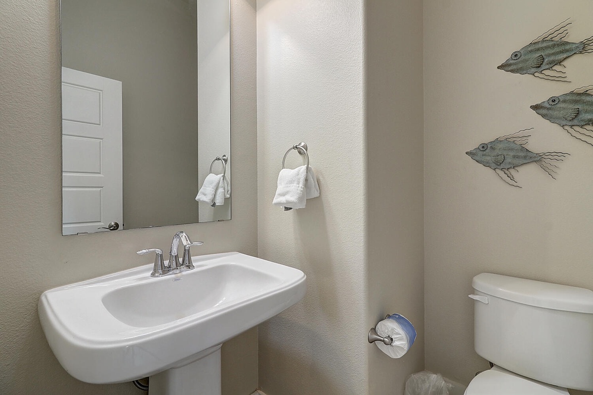Freshen up in your clean, well-appointed powder room with charming fish artwork and plush towels waiting for you.