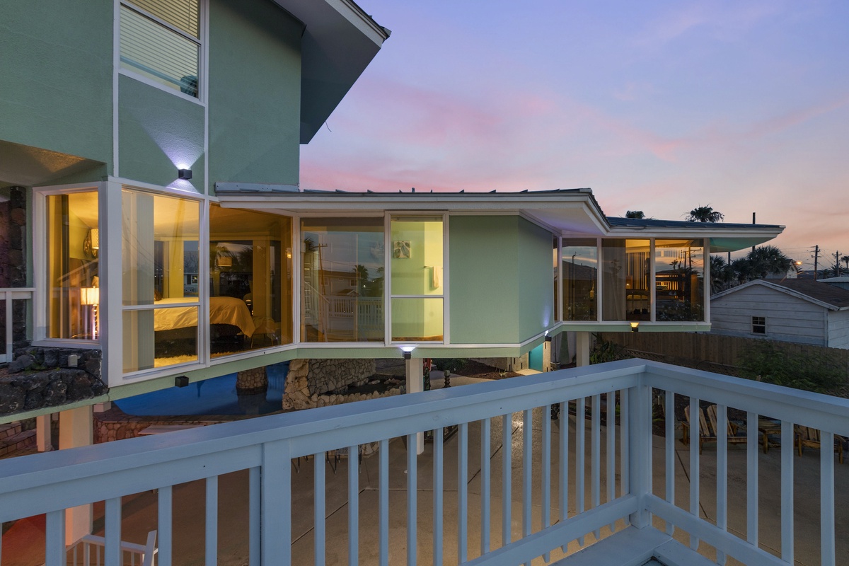 Modern vacation home with panoramic windows and sunset skies creating the perfect evening backdrop for your getaway.