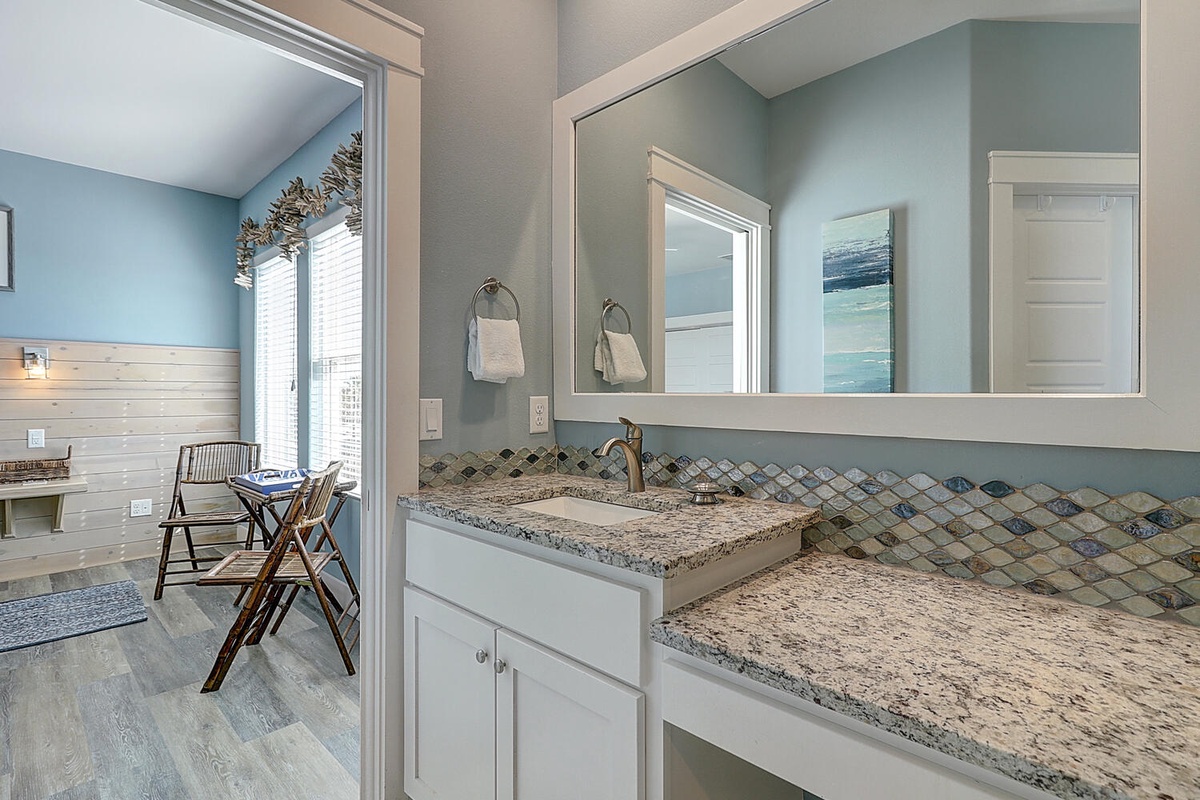 Your coastal-inspired bathroom features granite counters and elegant mosaic backsplash, creating a spa-like retreat for your morning routine.