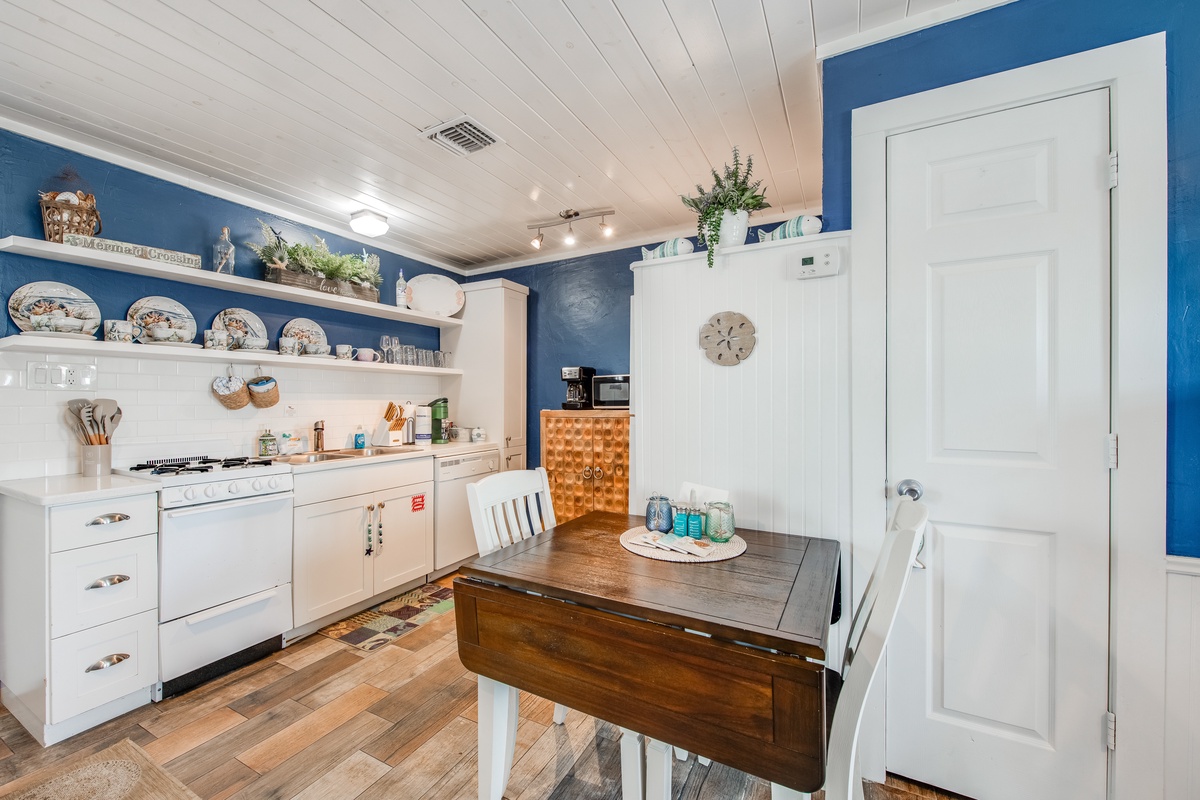 Your charming kitchen awaits with cheerful blue walls, vintage dishes, and everything needed for memorable meals together.
