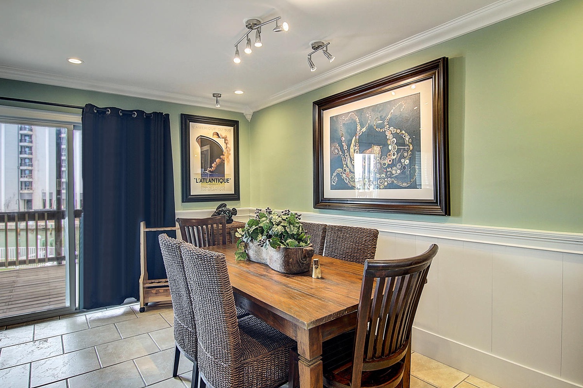 Your elegant dining space features coastal artwork and a wooden table where you'll savor meals together in this tastefully decorated room.