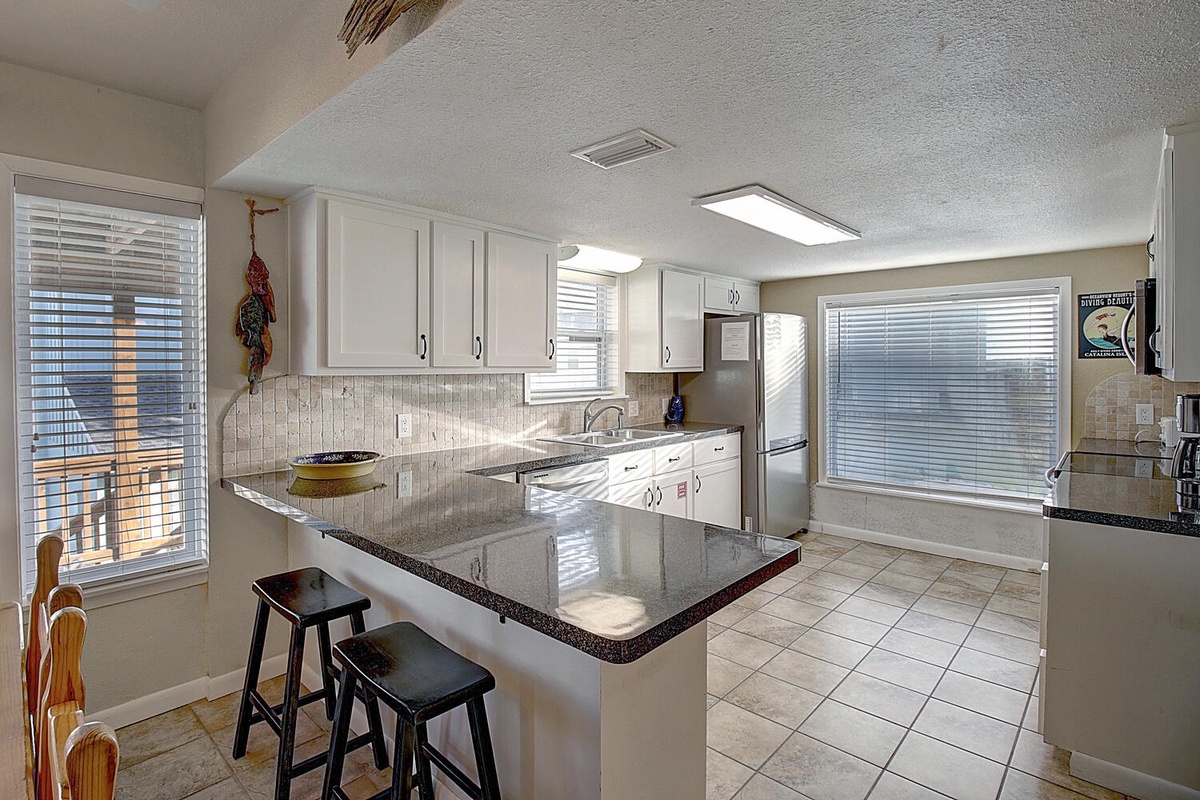 Your spacious kitchen offers granite countertops, modern appliances, and a breakfast bar perfect for morning coffee or casual dining.