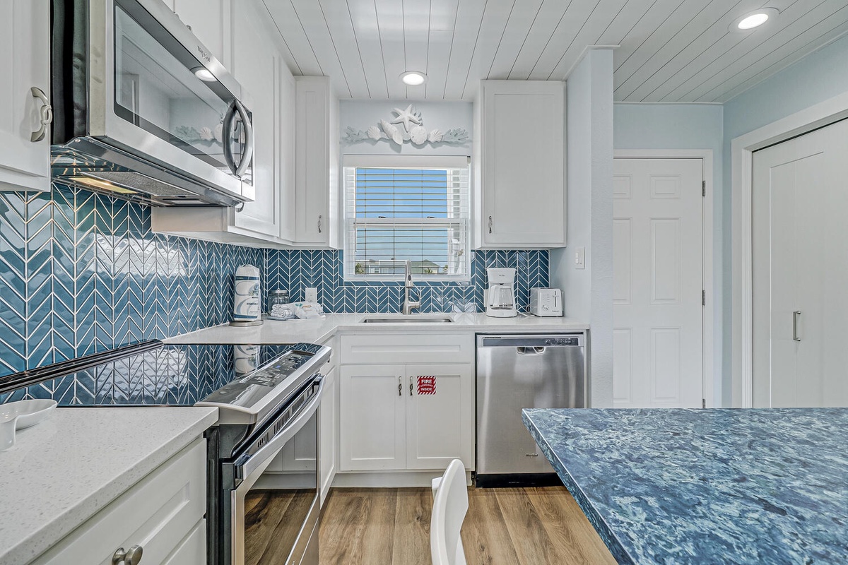 Your coastal kitchen features stunning blue herringbone tile and sleek appliances for creating memorable vacation meals together.