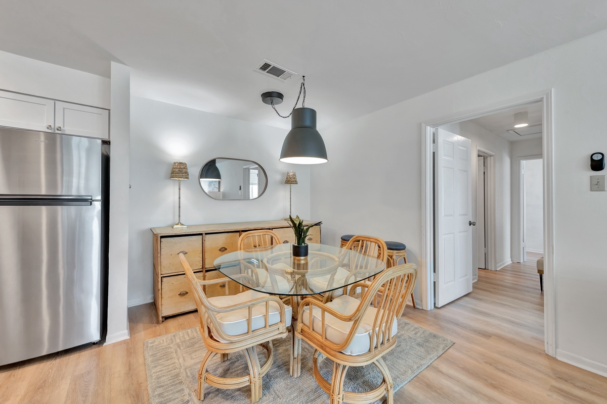 Gather around your stylish glass dining table, where warm wood tones and modern lighting create the perfect atmosphere for memorable meals together.