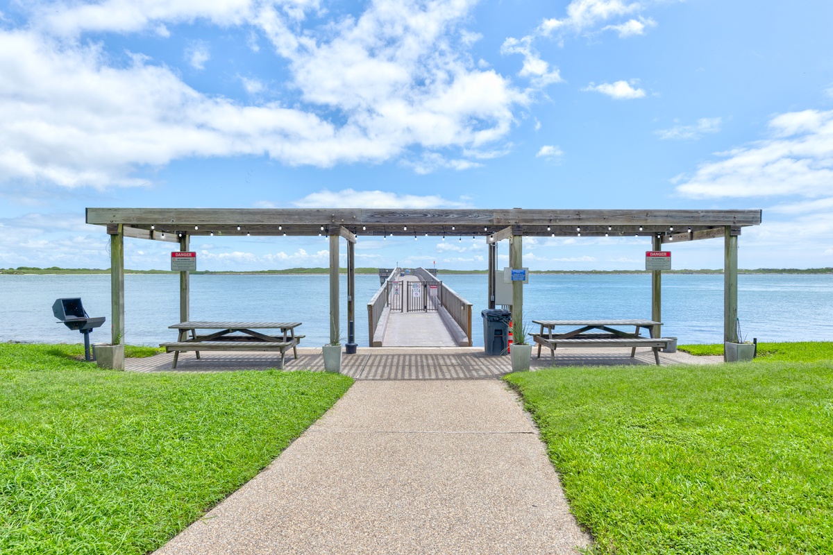 The property offers direct access to a scenic lakeside pavilion with picnic areas and a long pier stretching over tranquil waters, perfect for peaceful strolls.