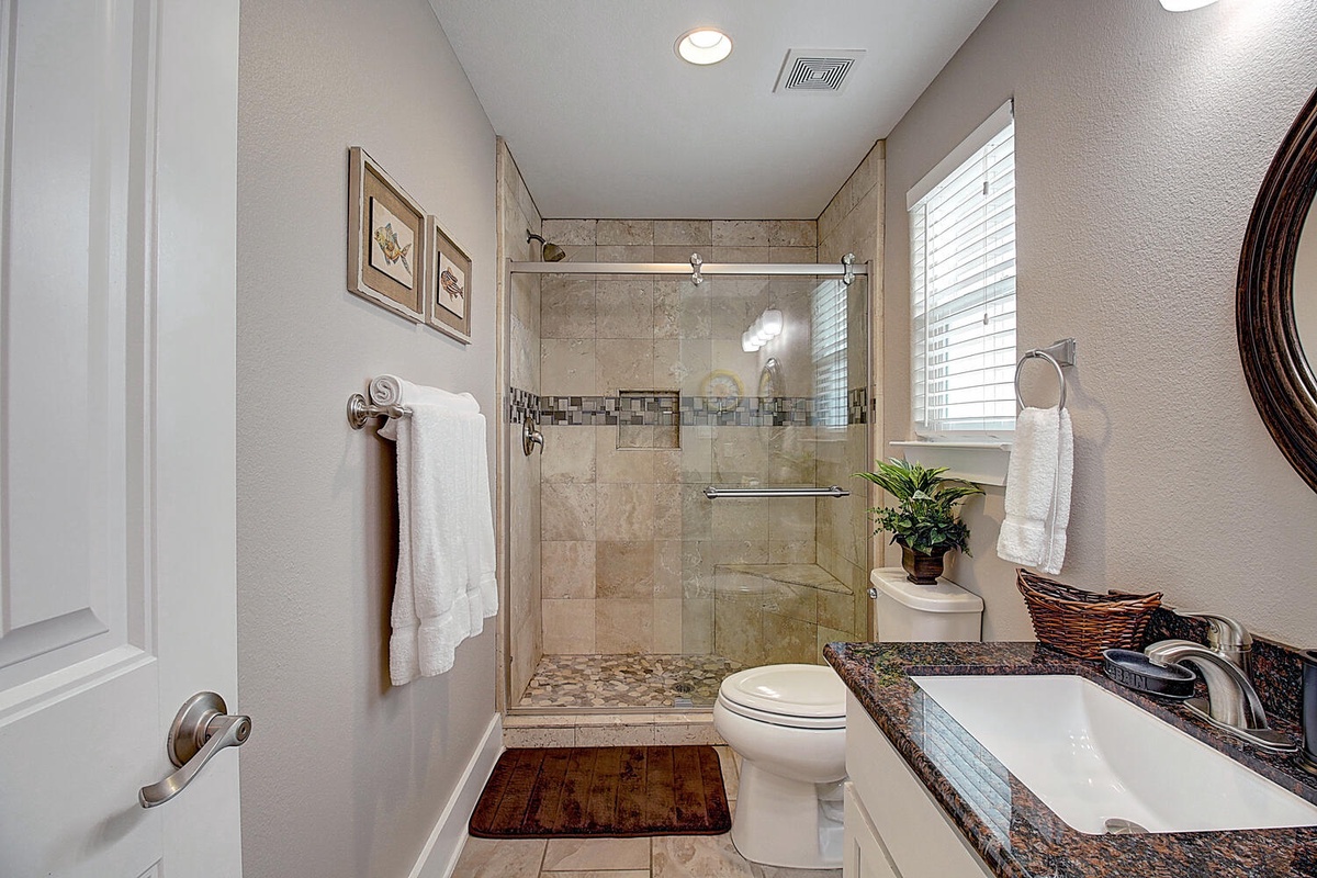 Step into your elegant bathroom featuring a spacious walk-in shower, granite countertops, and fresh towels waiting for your arrival.