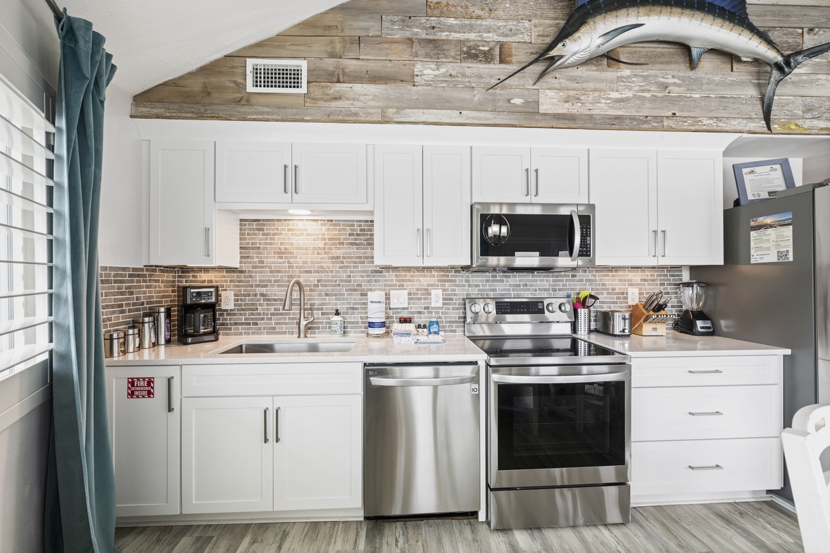 Cook your favorite meals in this fully equipped kitchen featuring stainless steel appliances, granite countertops, and charming brick backsplash.