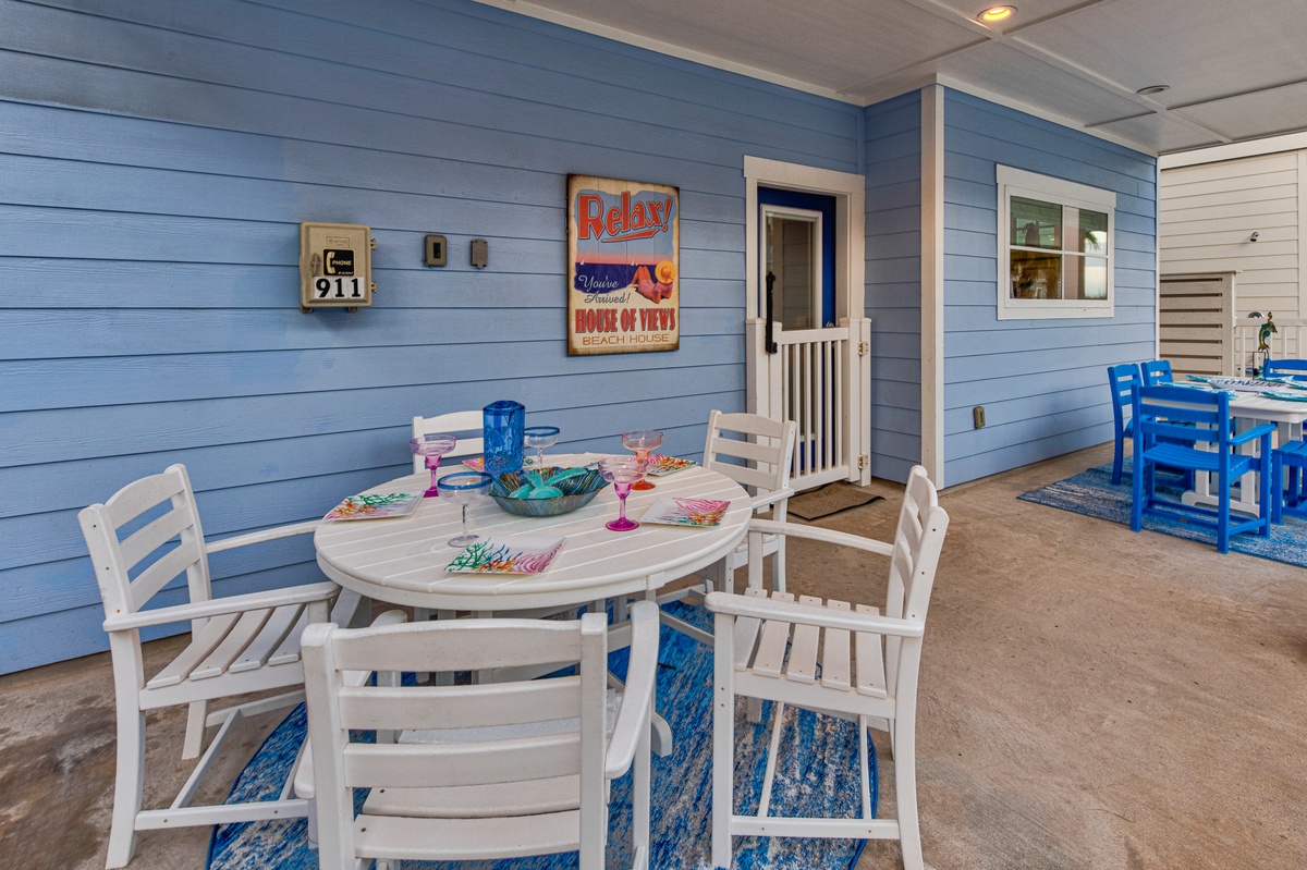Enjoy meals on your private covered patio with charming coastal decor and comfortable seating for beachside relaxation.