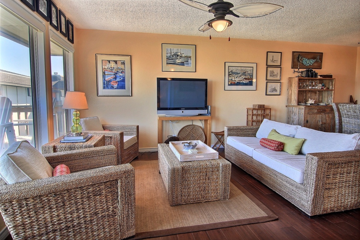 Sink into comfortable wicker seating while watching your favorite shows on the flat-screen TV in this nautical-themed living space.