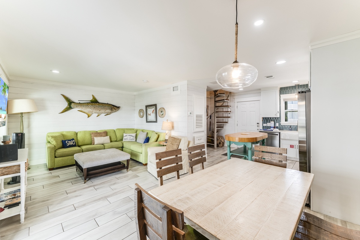 Gather in your bright, beachy living space—comfy sectional, open kitchen, and coastal charm invite relaxed togetherness and easy meal prep.
