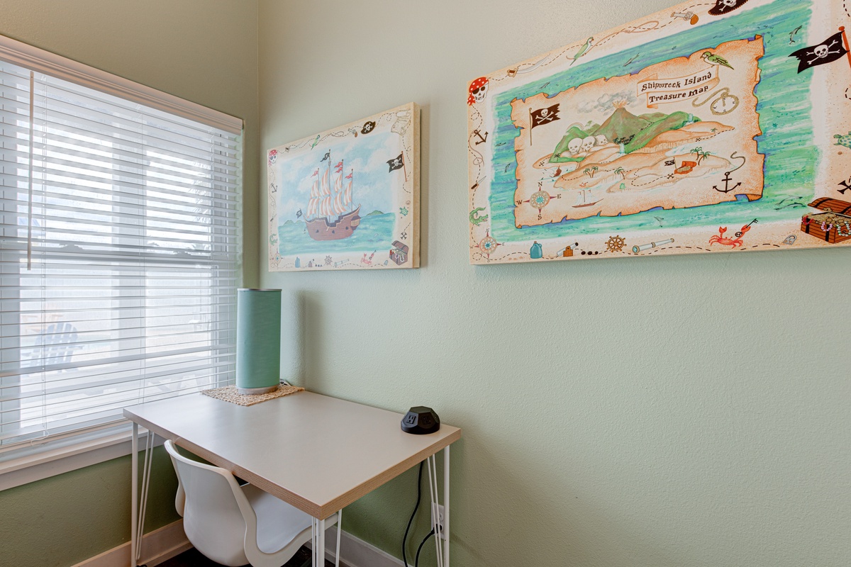 Your productivity soars in this cheerful workspace with natural light, playful pirate-themed art, and a clean modern desk.
