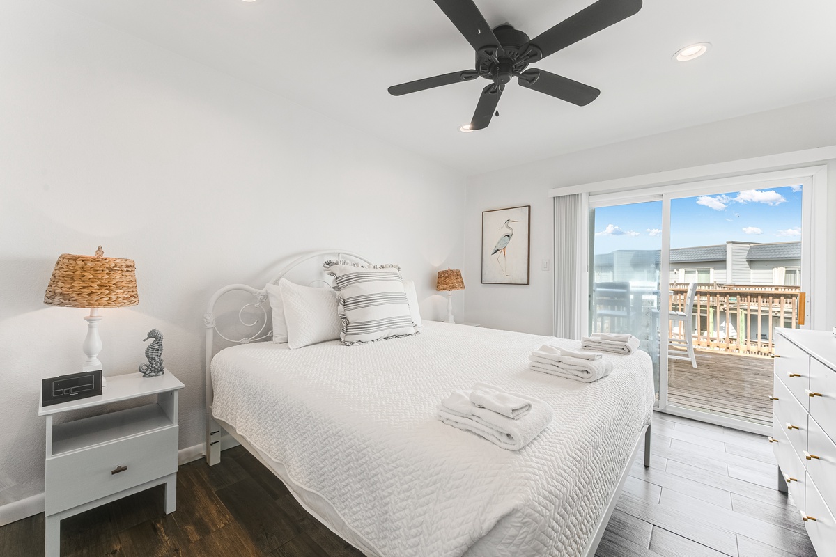 Wake up in your serene coastal bedroom where fresh linens await and sliding doors open to your private deck overlooking the water.