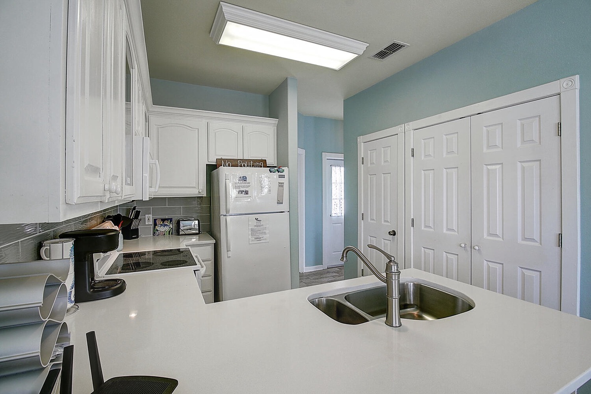 Your fully equipped kitchen features white cabinets, quartz countertops, and modern appliances for all your cooking needs.