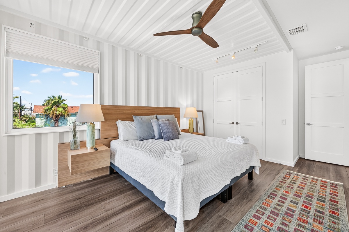 Wake up to soft breezes and serene water views from your primary bedroom with a king bed and crisp linens offering a calming coastal style.