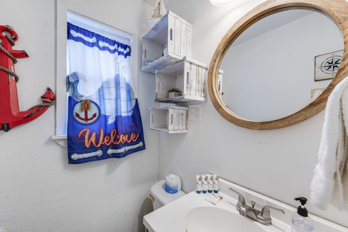 Freshen up in your charming nautical bathroom with coastal touches, white crates for storage, and thoughtful amenities.
