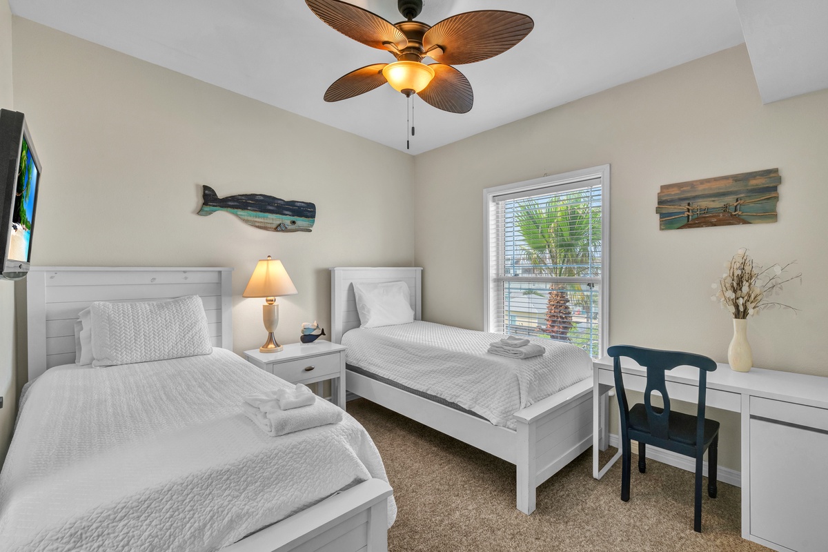 Settle into your coastal-themed bedroom with twin beds, ceiling fan, and tropical palm views for restful nights.