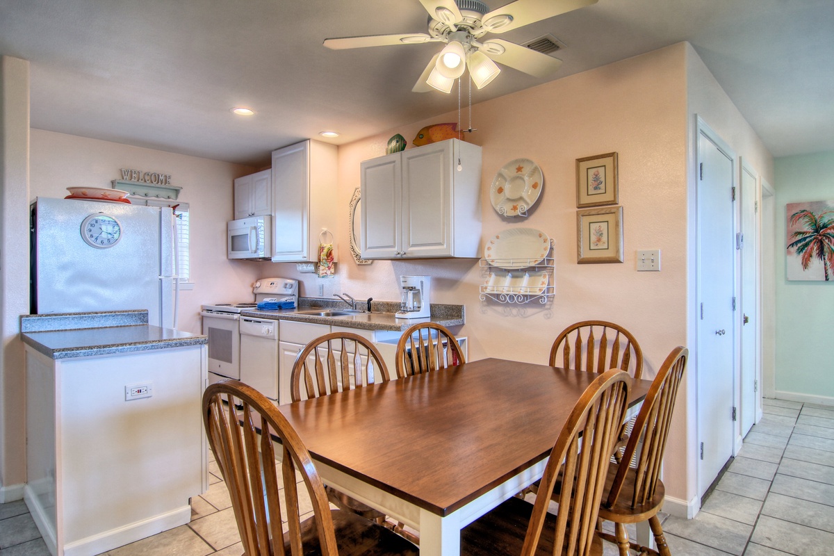 Your fully equipped kitchen flows into a cozy dining area where you'll gather for meals around the welcoming wooden table.