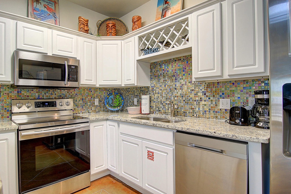 Your fully equipped kitchen features granite counters, stainless appliances, and tropical-themed décor that sets the perfect mood for your getaway.