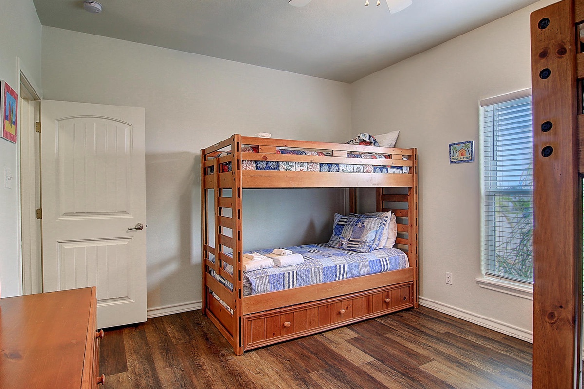 Your kids will love this cozy bunk bed room with warm wood floors and built-in storage drawers beneath.