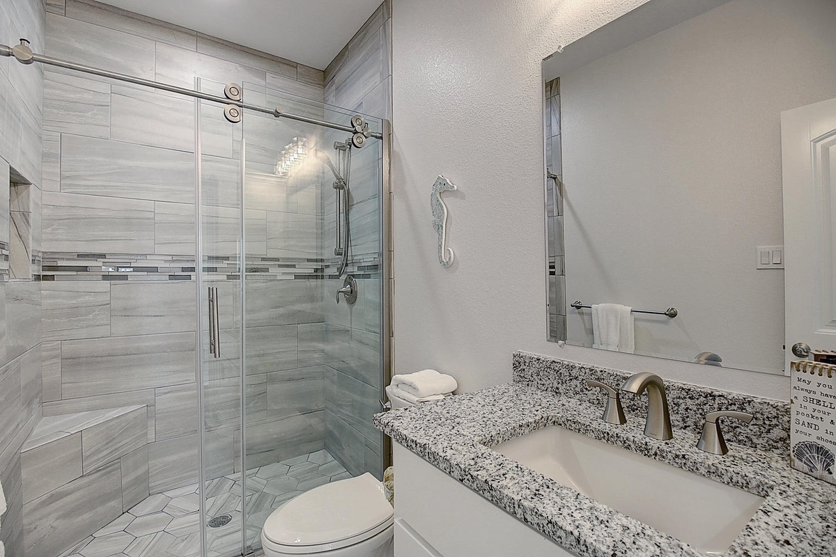 Step into your private spa-like bathroom featuring elegant granite counters and a luxurious walk-in shower with sleek glass doors.