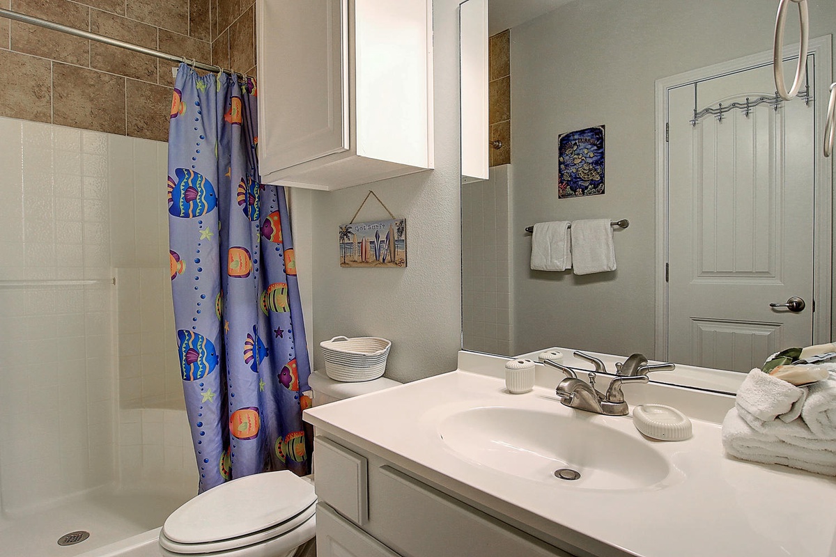 Refresh in your private bathroom with ocean-themed touches, soft towels, and everything you need for a comfortable stay.