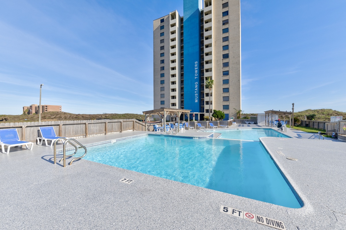 Modern tower complex with outdoor swimming pool and deck area for guest relaxation.