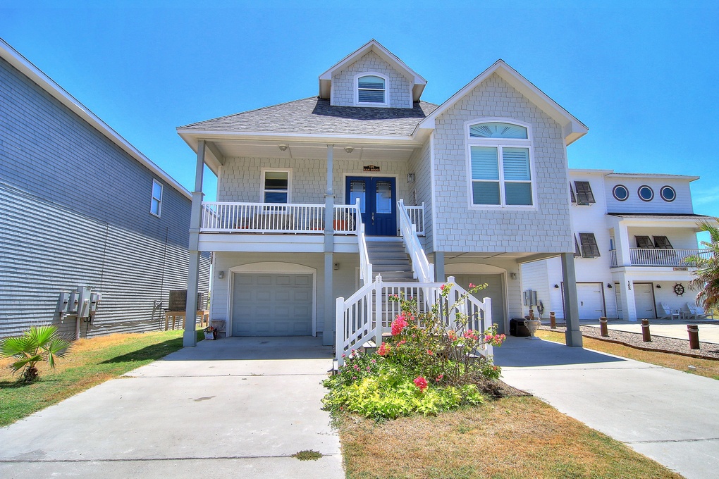 Charming coastal home with covered porch and garage parking in a peaceful beach neighborhood.