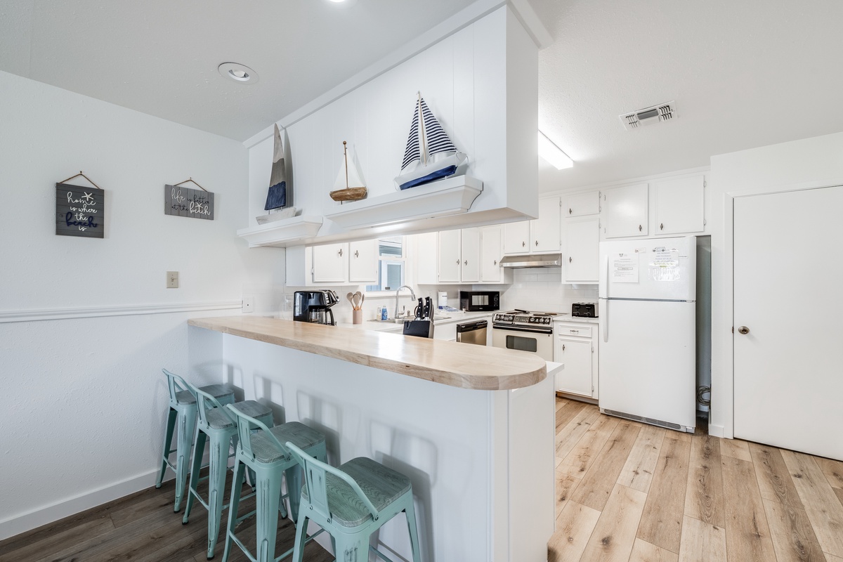 Cook your favorite meals in this bright, coastal-themed kitchen with full appliances and a breakfast bar for casual dining.