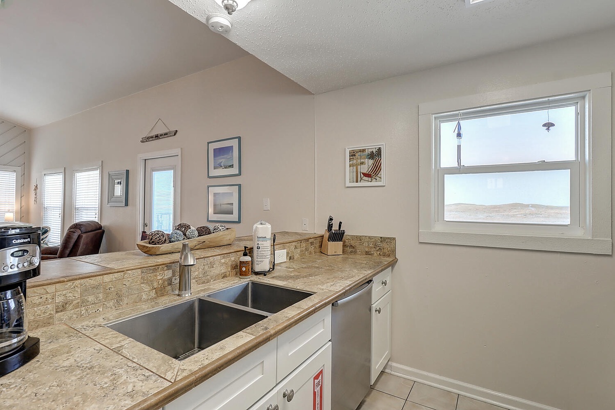 Your fully equipped kitchen features granite countertops and a double sink, perfect for preparing meals with stunning mountain views through the windows.