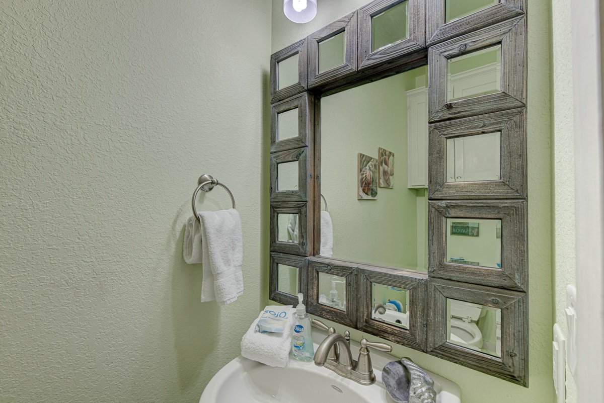 Refresh in your stylish bathroom featuring a unique mosaic mirror and thoughtful amenities for your comfort.