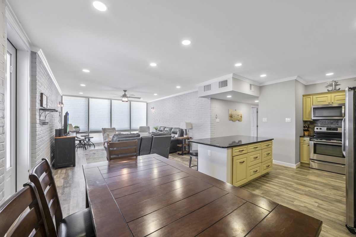 Your open-concept living space flows seamlessly from kitchen to lounge, with sunny windows and cozy seating perfect for relaxing together.