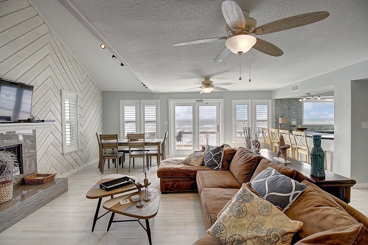 Relax in this stylish open living space with plush leather seating and stunning ocean views through floor-to-ceiling windows.