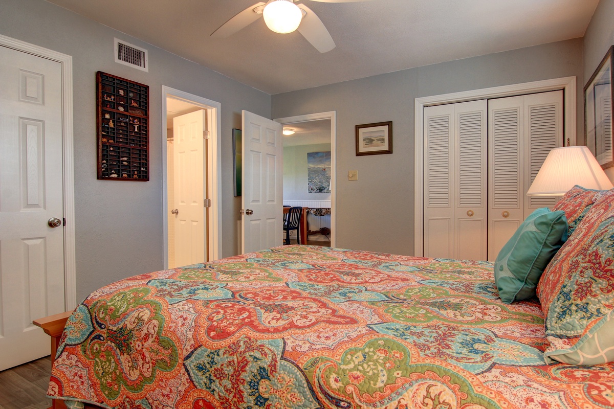 Unwind in your cozy bedroom with vibrant paisley bedding, ceiling fan comfort, and thoughtful touches that make this space feel like home.