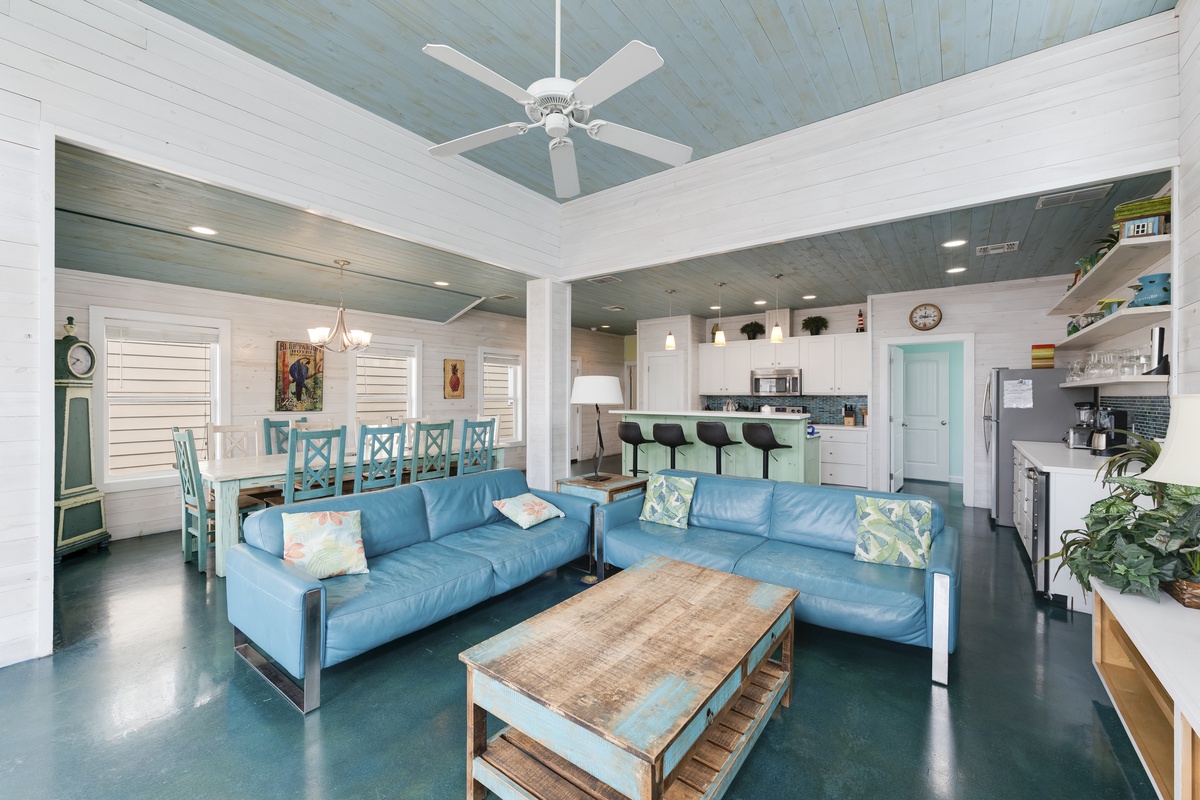 Relax in your spacious open-plan living area with coastal blue sofas and stunning turquoise ceiling beams overhead.