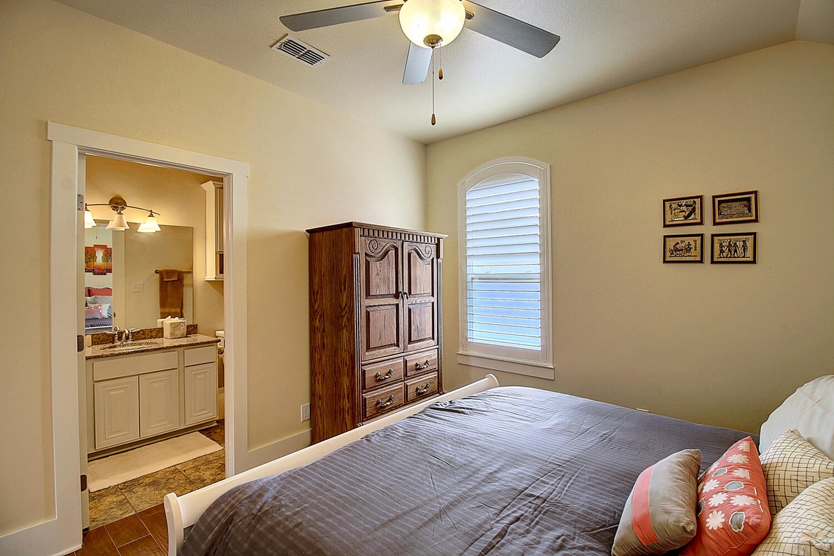Relax in your peaceful bedroom with natural light, ceiling fan comfort, and an attached bathroom for ultimate convenience.