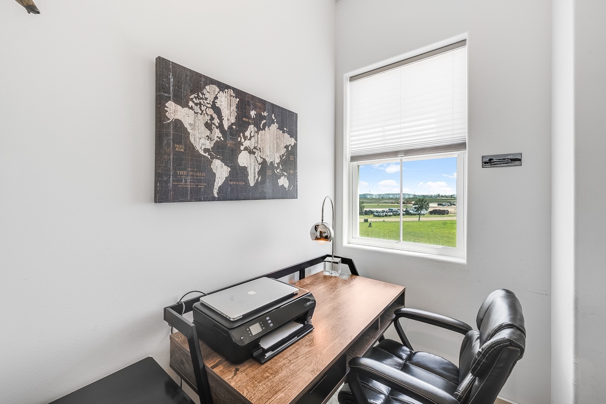 Your dedicated workspace awaits with natural light and inspiring world map art to fuel your productivity and wanderlust.