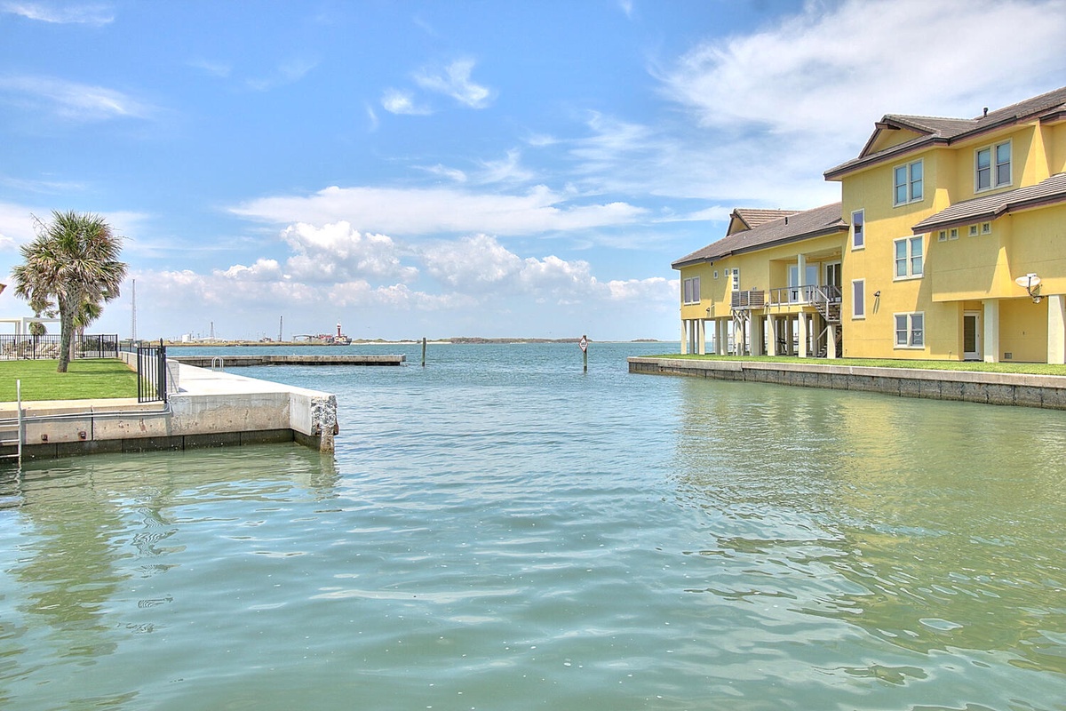 Waterfront property with direct canal access and bright yellow buildings overlooking serene waters.