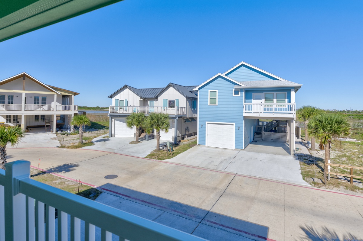 Coastal neighborhood with elevated beach houses and palm trees creates a perfect vacation setting.