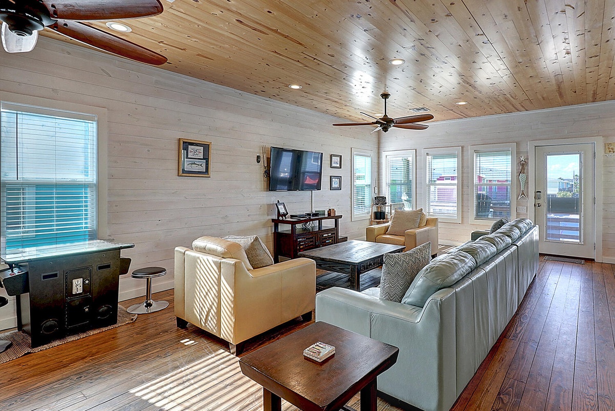 Sink into plush seating while warm wood ceilings and abundant windows create your perfect gathering space for movie nights and memorable conversations.