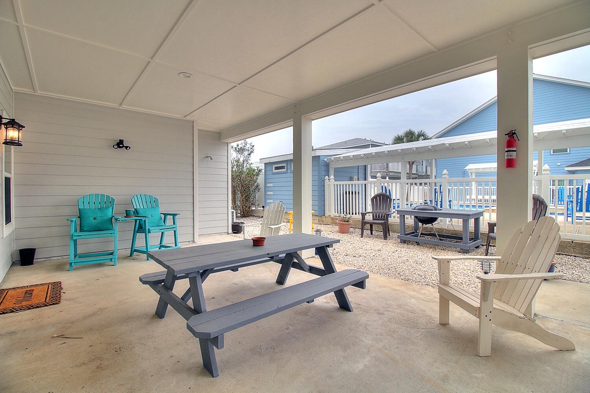 Relax on your private covered patio with picnic table, colorful Adirondack chairs, and peaceful neighborhood views.