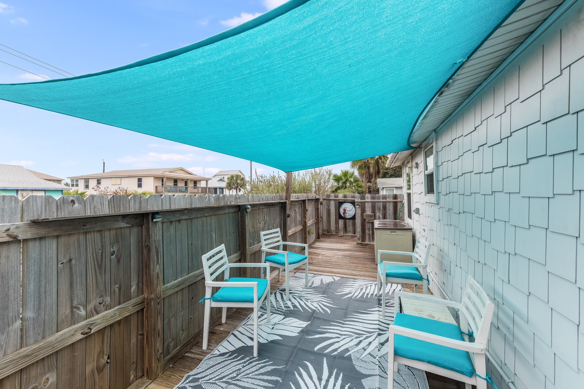 Your private deck offers turquoise cushioned chairs under a shade sail, perfect for morning coffee or evening relaxation.