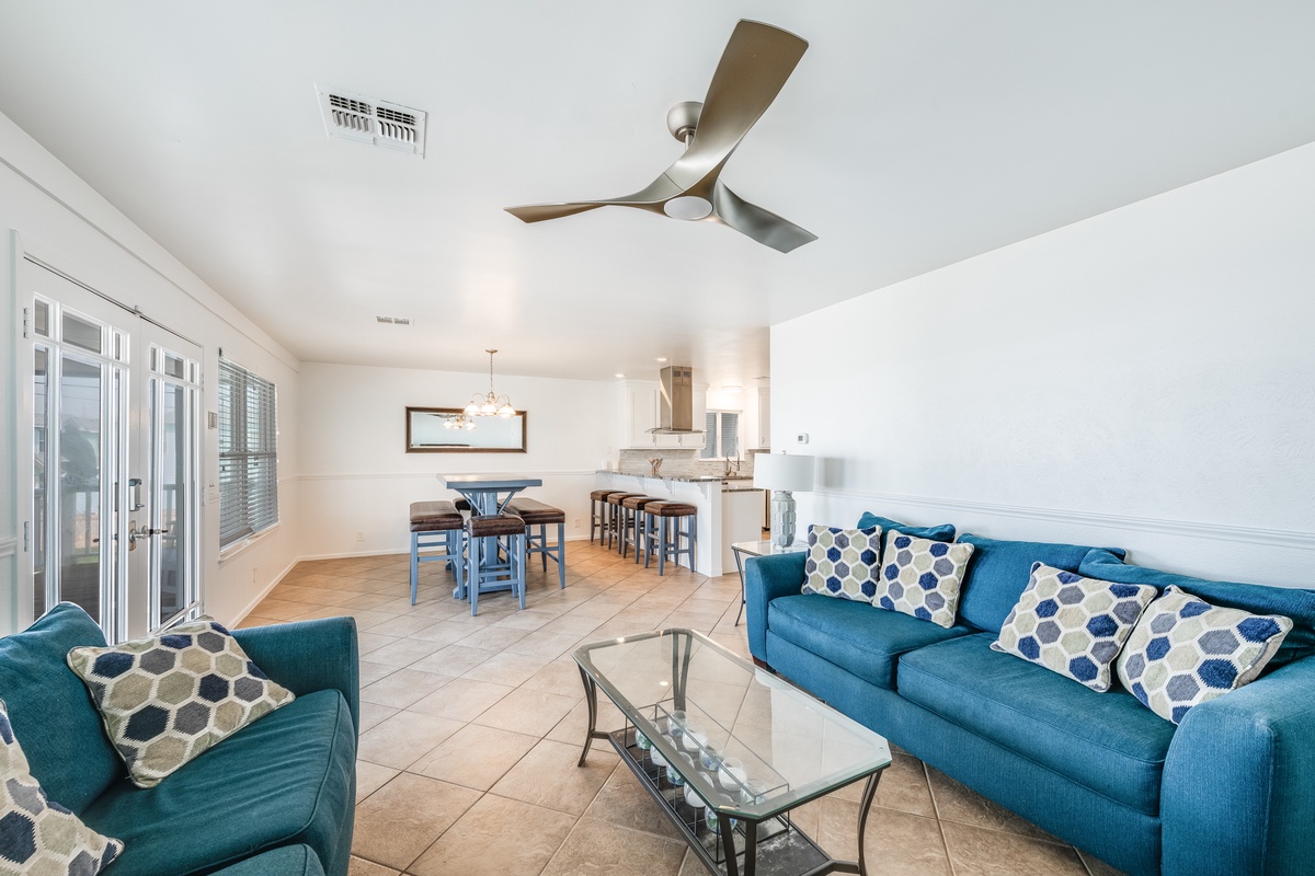 Relax in your bright, open living space with cheerful blue furnishings and modern ceiling fan keeping you cool.