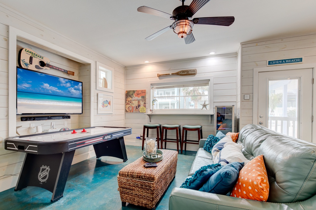 Unwind in your beach-themed game room with air hockey, coastal décor, and comfy seating for endless family fun.
