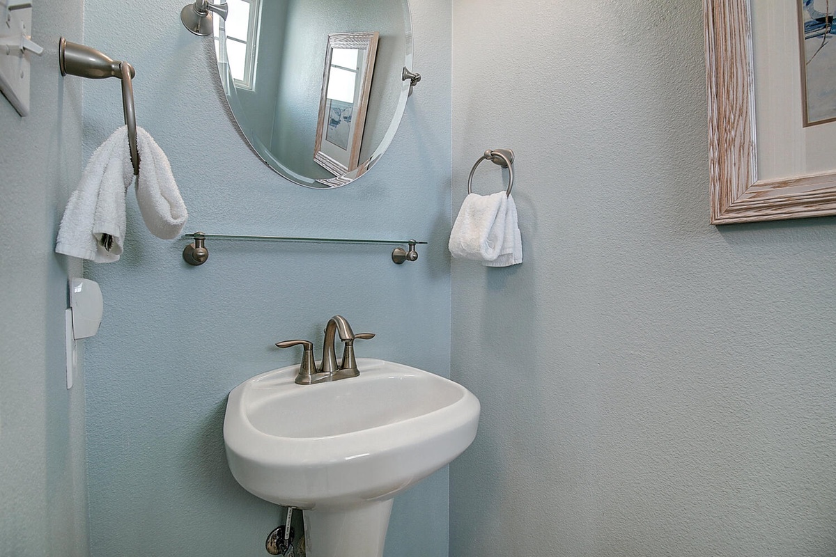 Fresh towels await in your bright, well-appointed powder room with modern fixtures and calming blue accents.