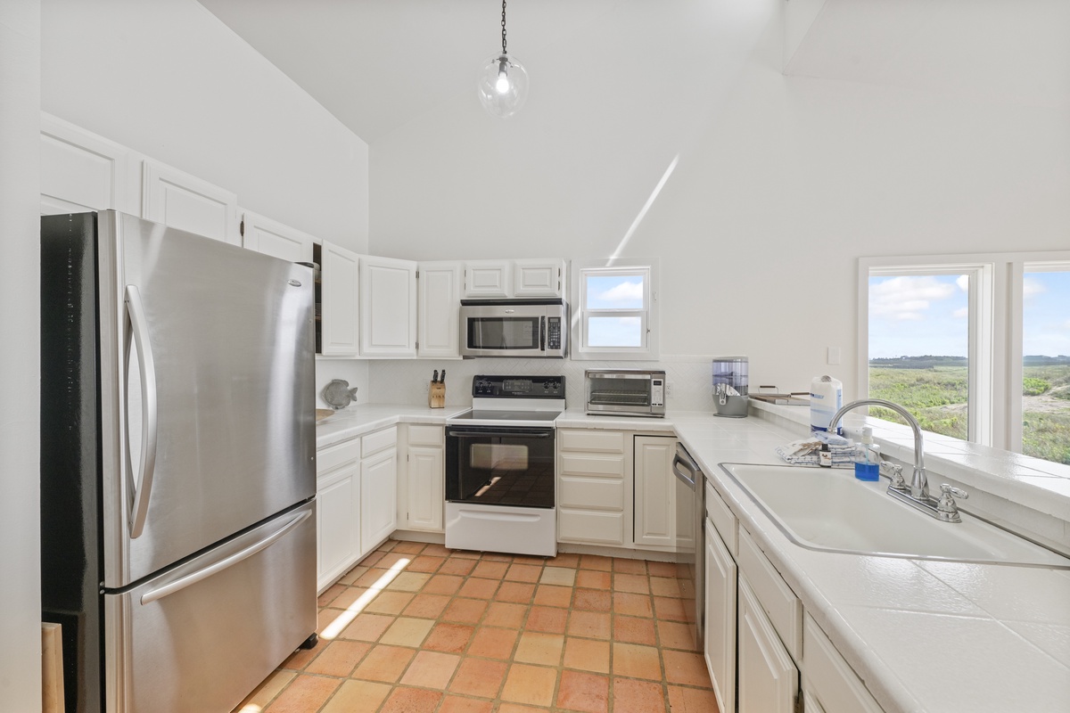 Your fully equipped kitchen awaits with stainless steel appliances and scenic views through bright windows.