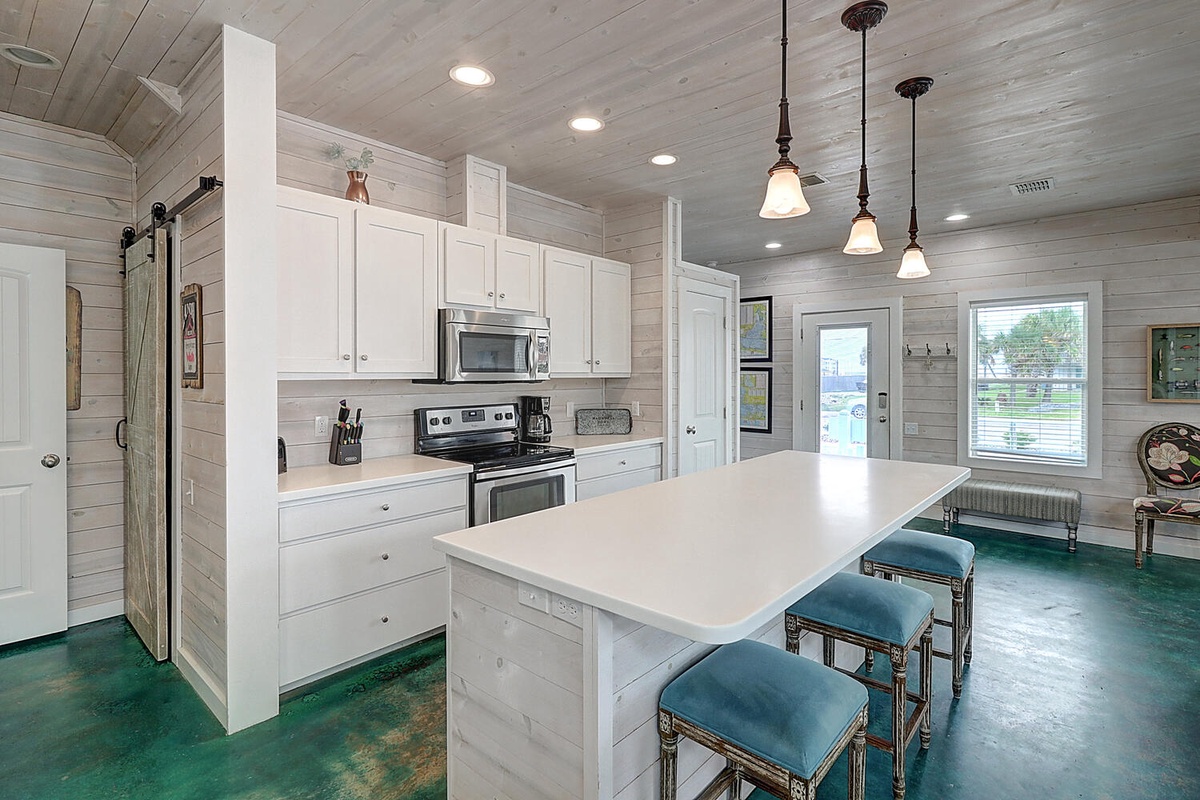 Gather around this stunning kitchen island where crisp white cabinets meet bold turquoise floors, creating your perfect space for morning coffee and evening conversations.