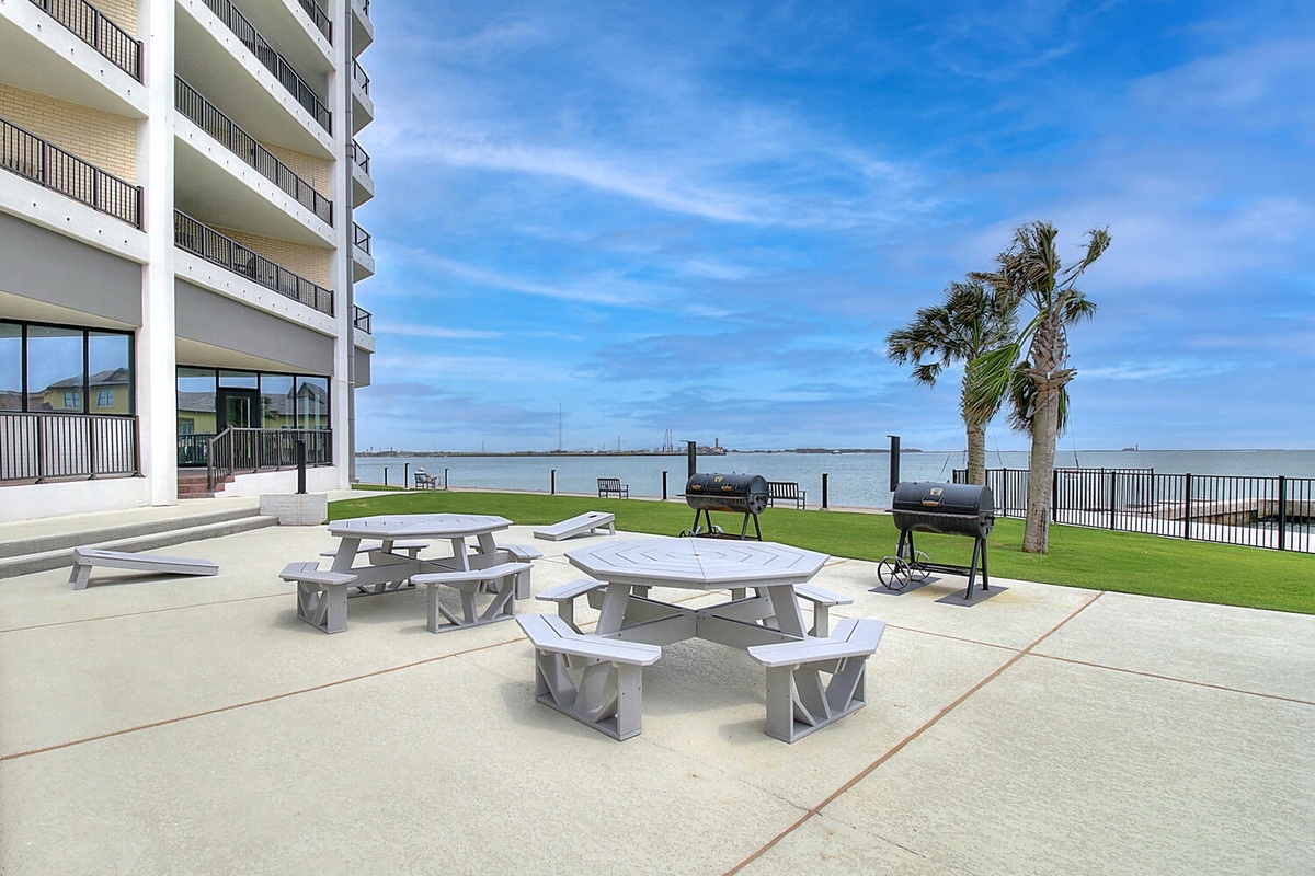 Gather with friends at waterfront picnic tables where ocean breezes and BBQ aromas create perfect outdoor dining moments.