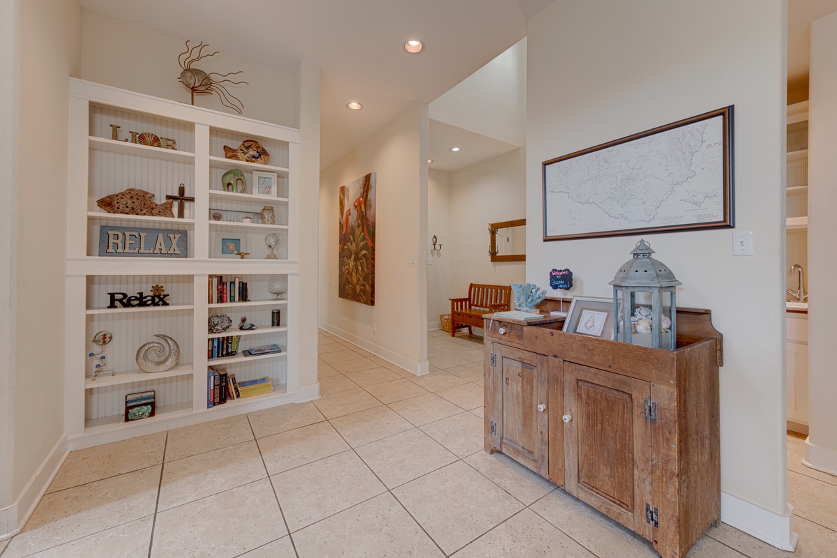 Your private hallway invites relaxation with thoughtful built-in shelving displaying local treasures and a rustic wooden console showcasing coastal charm.