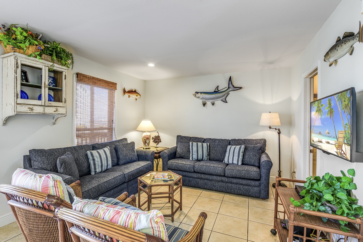 Sink into plush sofas in your coastal-themed living room, where fish art and tropical touches create the perfect beach getaway atmosphere.